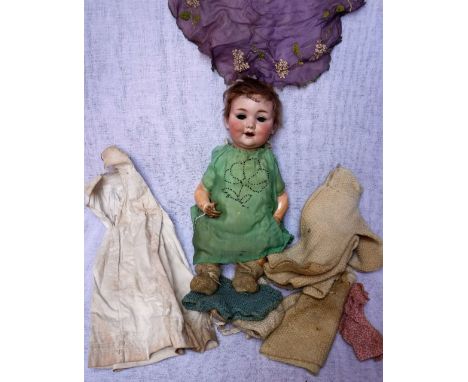 A 1930S CERAMIC HEADED DOLL stamped 'A. M.' and a collection of period clothes