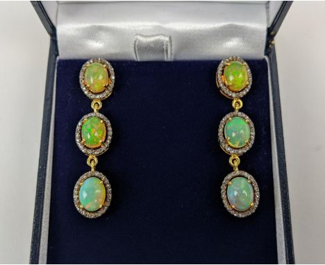 A PAIR OF SILVER-GILT OPAL AND DIAMOND SET PENDANT EARRINGS, of triple sectioned droplet form, each droplet with a cabouchon 