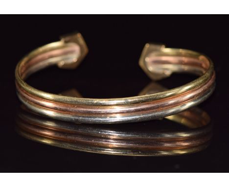 A 9ct gold tri-coloured bangle, 9.5g&nbsp;