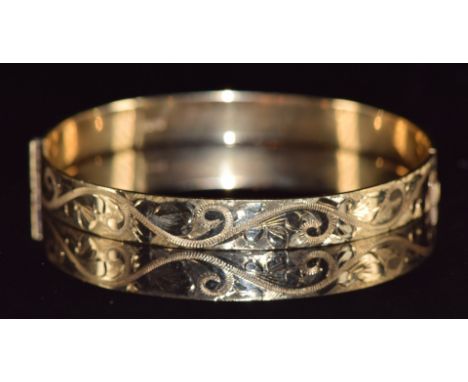 A 9ct gold bangle with engraved decoration, 15.8g&nbsp;