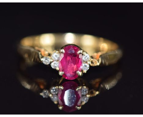 An 18ct gold ring set with an oval cut ruby and diamonds (one diamond missing), 2.7g, size N