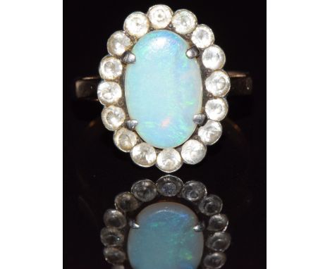 A 9ct gold ring set with an opal surrounded by white sapphires, 2.9g, size P