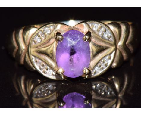 A 9ct gold ring set with an oval cut amethyst and diamonds, 2.3g, size P