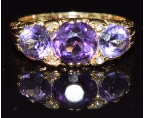 A c1920 18ct gold ring set with three amethysts and four rose cut diamonds, 5.2g, size L