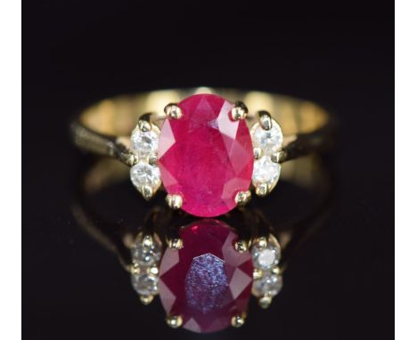 A 14k gold ring set with an oval cut ruby and four diamonds, 3.4g, size O