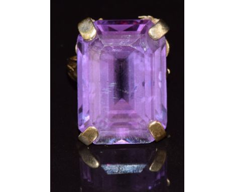 An 18k gold ring set with a synthetic purple sapphire, 14.4g, size O