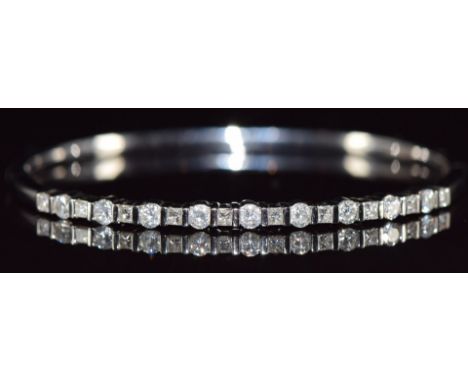 An 18ct white gold bangle set with nine round brilliant cut diamonds and ten princess cut diamonds, total diamond weight 1.7c