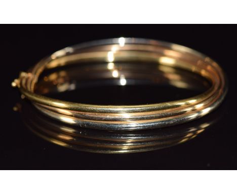 An 18ct gold tri-coloured bangle, 11.9g