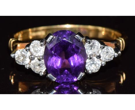 An 18ct gold ring set with an oval cut amethyst and six old cut diamonds in a platinum setting, 4.6g, size Q