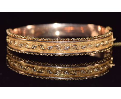 A 9ct gold bangle with scrolling decoration, Birmingham 1915, 9.8g&nbsp;