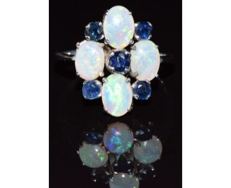 An 18k white gold ring set with four oval opal cabochons and five sapphires, 3.6g, size P