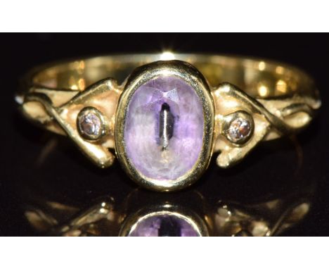 An 18ct gold ring set with an oval cut amethyst and two diamonds, 3.5g, size L - see lot 691 for matching wedding band