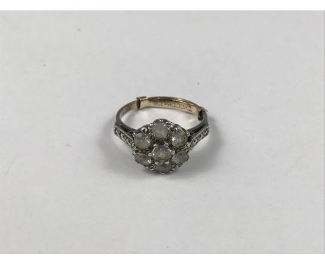 An early 20th Century yellow-metal and paste flower-head cluster dress ring, having marcasite set shoulders, stamped '9ct', t