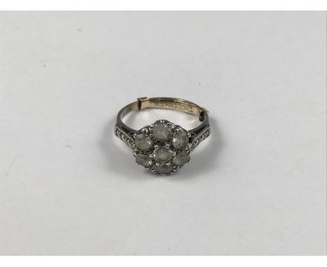 An early 20th Century yellow-metal and paste flower-head cluster dress ring, having marcasite set shoulders, stamped '9ct', t