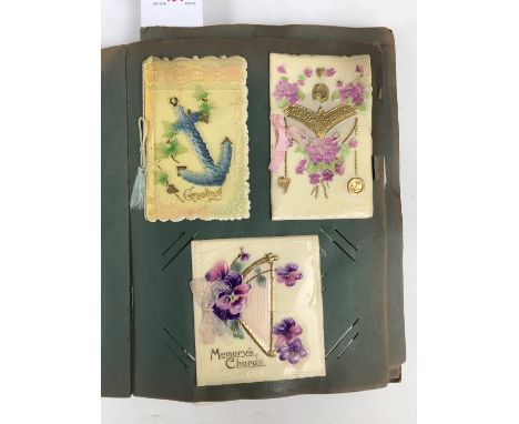 An early 20th Century postcard album containing numerous celluloid and other postcards