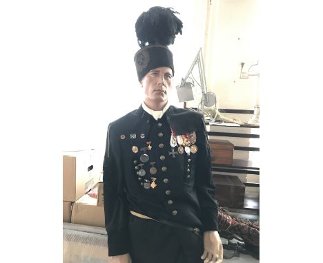 A mannequin display German coal miners' organization uniform, bearing numerous items of insignia and medals, with greatcoat
