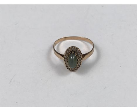 A yellow-metal, green tiger's eye and split seed pearl dress ring, having a central navette shaped cabochon claw-set within a