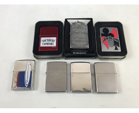 Four Zippo lighters together with a Southern Comfort Zippo lighter, a Jim Bean Zippo lighter and a Jack Daniels Zippo lighter