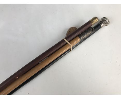 A Victorian slender ebonized walking cane with silver pommel, a swagger stick with silver pommel and one other 