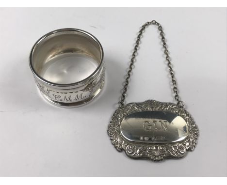 A silver napkin ring together with a silver bottle ticket for 'Gin'