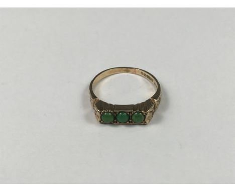 A 9ct gold and turquoise three-stone dress ring, the cabochon stones being sunken and pellet set to the face of a decorativel