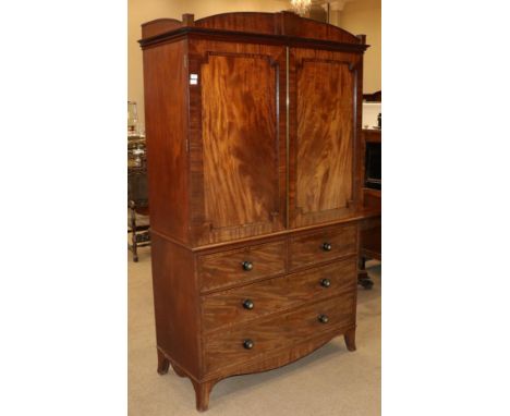 A Regency Mahogany, Ebony Strung and Brass Inlaid Linen Press, early 19th century, the arched pediment above two recessed cup