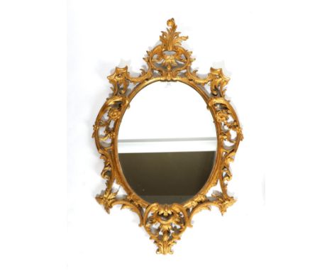 A Carved Giltwood Mirror, in Chippendale style, the oval plate contained within an acanthus C scroll and floral decorated fra