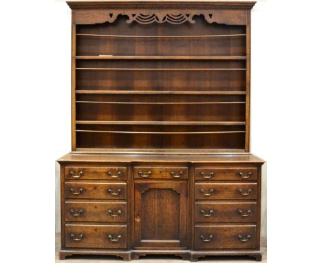 A George III Enclosed Dresser and Rack, late 18th century, the dentil cornice above a fret cut frieze and four fixed shelves,