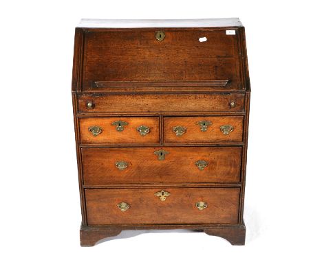 An 18th Century Oak Bureau, of small proportions, the fall enclosing a fitted interior of pigeon holes and four small drawers