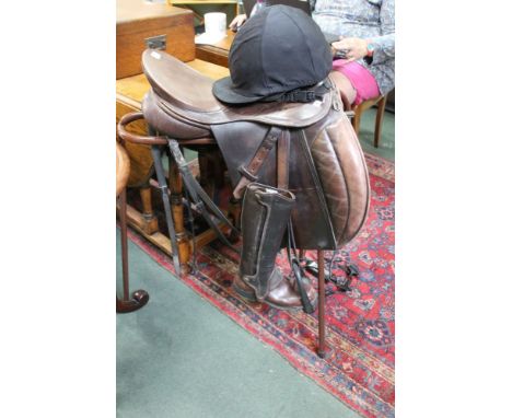 A horse riding saddle, bridle, boots, hat, crop, stand, together with a hunting print