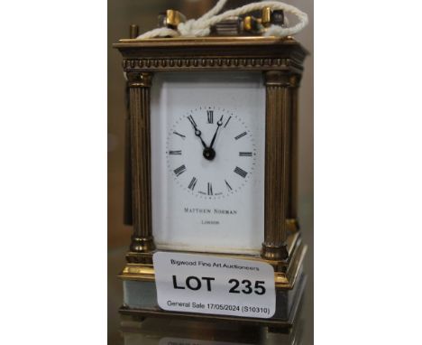 A "Matthew Norman" carriage clock, brass column framed five glass case, with hinged bale handle and key, case 9cm high