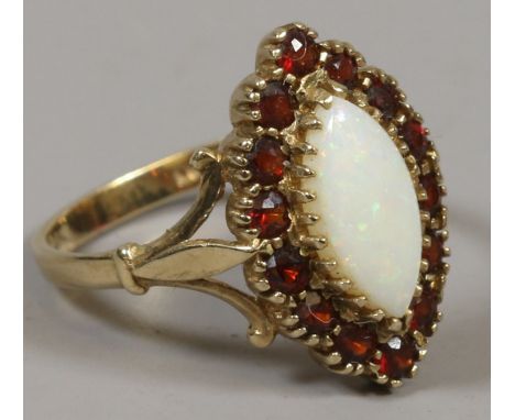 A 9ct gold opal and garnet ring with large central ring surrounded by 14 smaller stones size Q 3.74 grams gross.