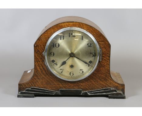 An oak Art Deco mantel clock with Arabic numeral dial enclosing three train movement with key.