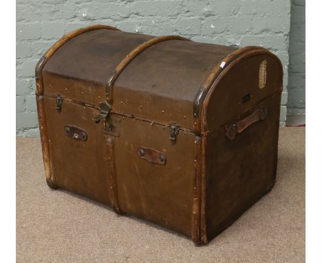 A metal bound reinforced canvas dome top travel trunk with wood and leather trim and bearing riveted label of Crystal Palace 