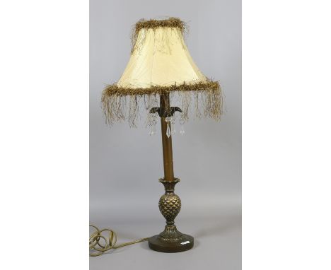 A decorative bronzed table lamp raised on a pineapple form base.