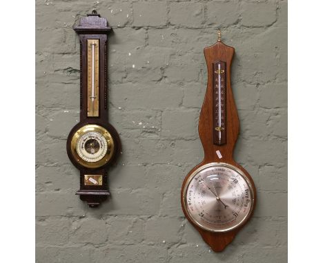 A carved oak wall barometer and similar banjo barometer.