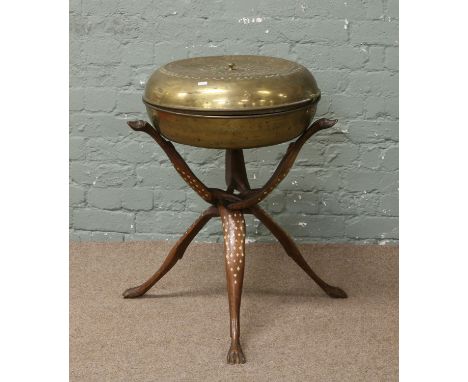 An unusual eastern brass lidded bowl stood on a tripod support with dog lead finial and paw feet.