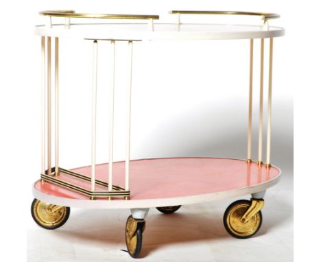 A retro vintage 1950's cocktail serving drinks bar trolley. The trolley of oval form with tubular gallery bar edge, two tiers