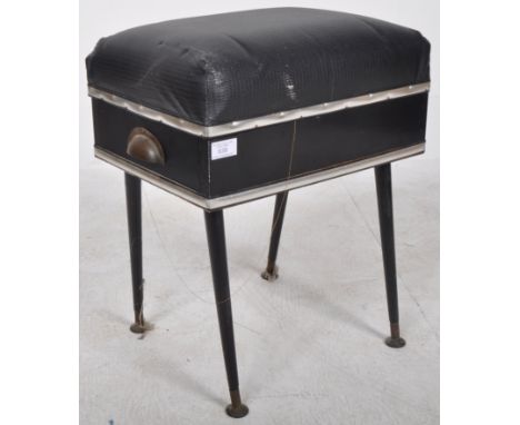 A retro vintage mid 20th Century sewing work box / stool having a cushioned faux black leather lid opening to reveal a fitted