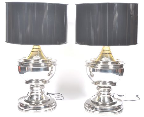 A pair of large / oversized chrome table lamps. Each lamp being of baluster form with large oversized black cylindrical shade