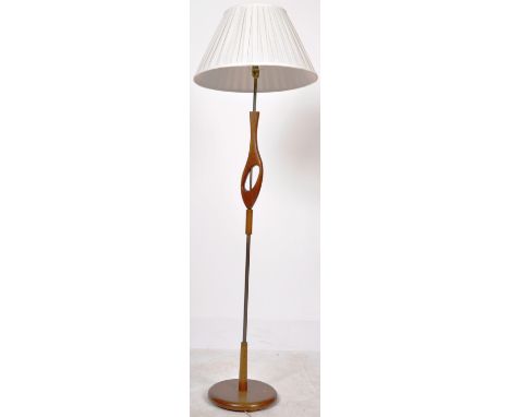 A retro mid 20th Century 1960's teak wood floor standing standard lamp light having a single brass stem with carved teak deco