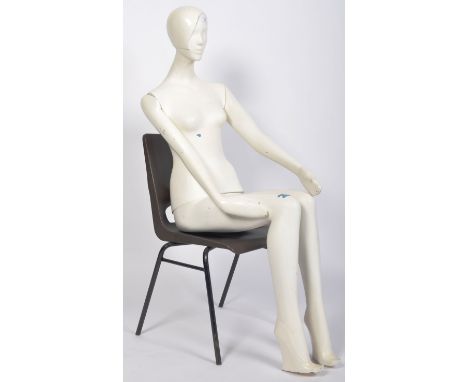 A 20th Century Art Deco style haberdashery shop display clothing mannequin. The female mannequin modelled in a seated positio