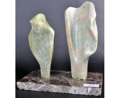A mid Century modern marble and soapstone sculpture art piece featuring two shaped soapstone fragments mounted to a red marbl