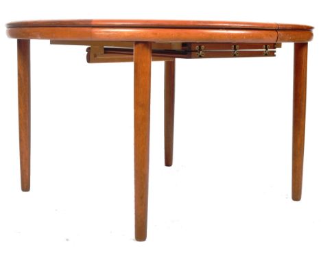 A retro vintage 1960's Danish teak wood dining table of circular form. The dining table having pull out sections with central