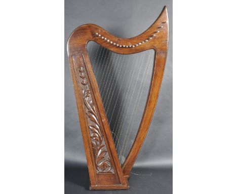 A retro vintage 20th Century Irish / Celtic carved wood 22 string harp. The harp of traditional form with carved flowers and 