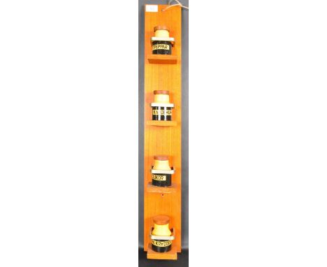 A retro vintage 1960's Swedish teak wood spice rack. The wall mounted spice rack having four shelves complete with pottery sp