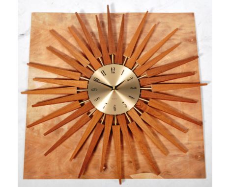 After George Nelson - Star Clock - A contemporary star shaped wall clock. The clock comprising of teak wood and brass starbur