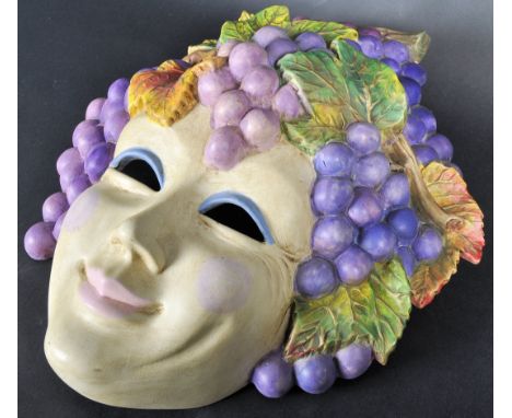 A vintage mid 20th Century Italian ceramic wall hanging face mask having grape vines and leaves form the hair with painted fa