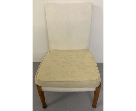 A vintage beach framed low bedroom chair by Parker - Knoll with yellow floral removeable covers.   Approx. 79cm tall.