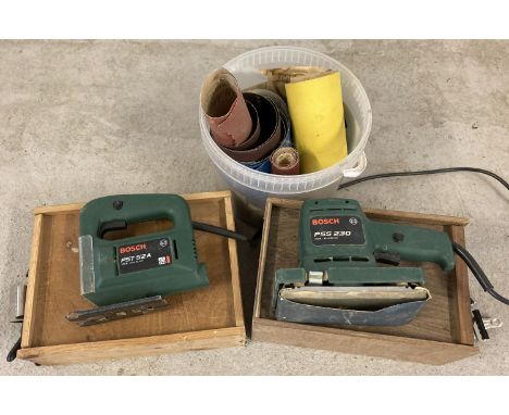 A Bosch PSS230 Orbital Sander together with a Bosch PST52A Jigsaw and a tub of sandpaper. Both in original cardboard boxes an